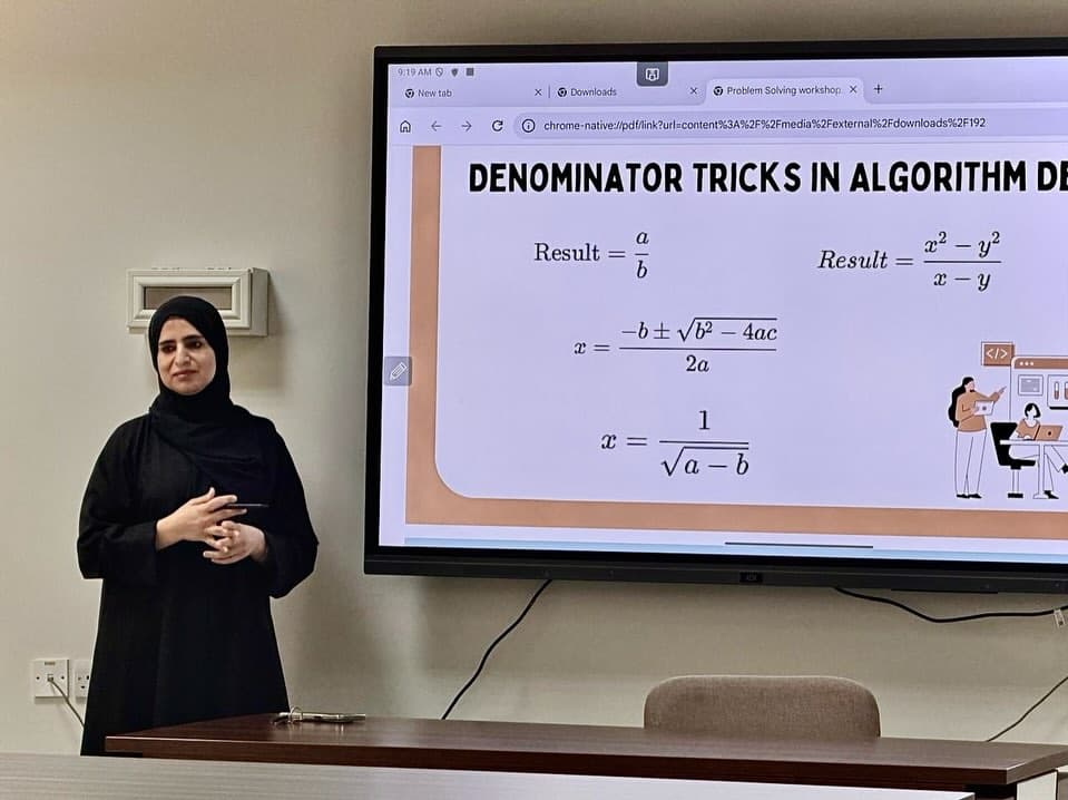 A workshop presenter beside a slide about algorithms